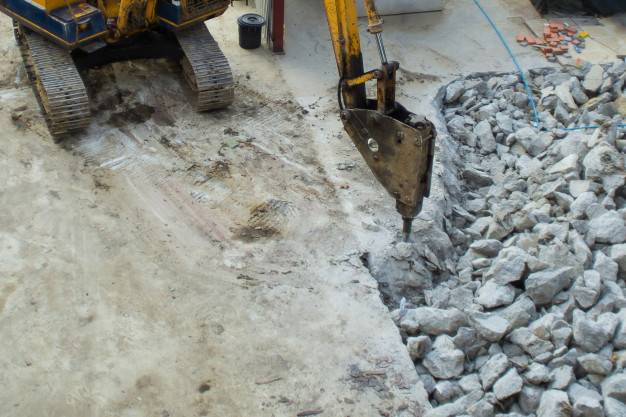 demolition-excavator-with-hydraulic-jack-hammer-is-destroying-concrete-slab_44576-71